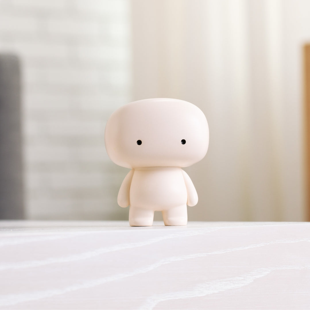 Blumo figure standing at the edge of a white countertop in a living room setting
