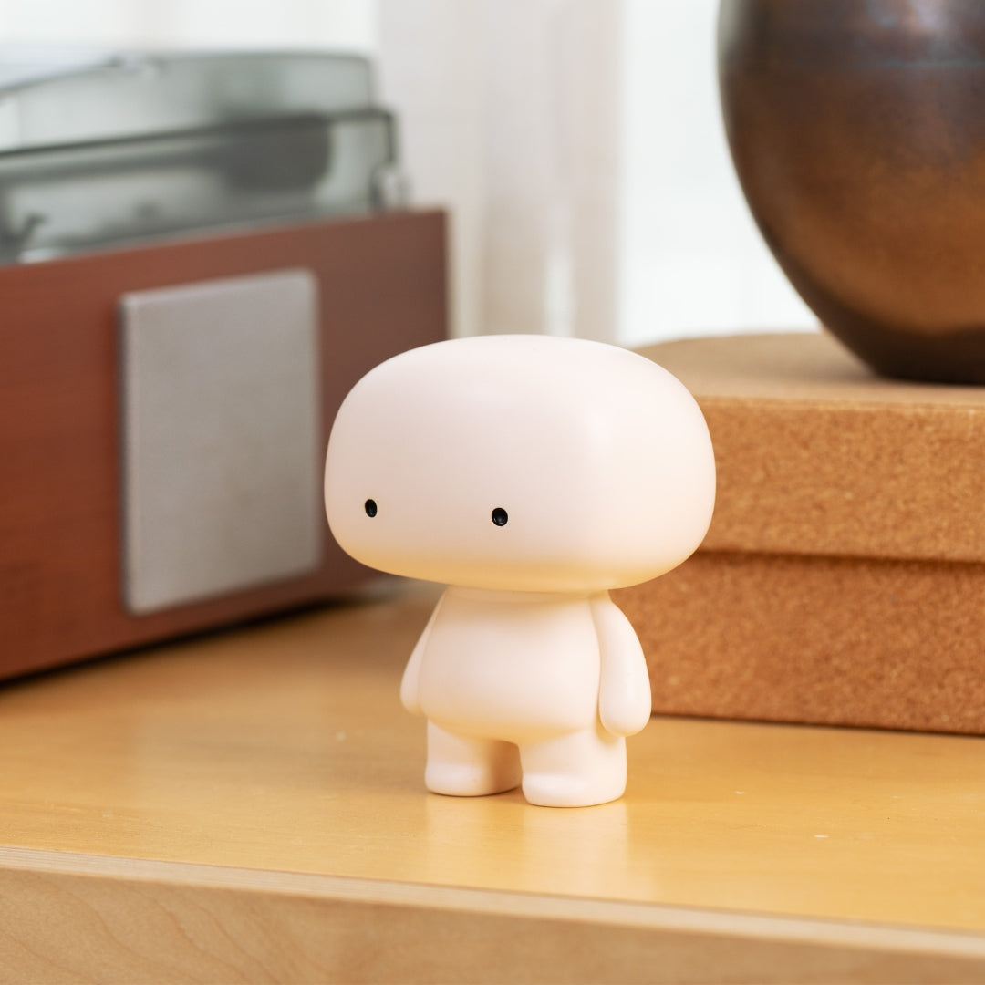Blumo figure on a wooden credenza beside a vintage turntable and ceramic vase