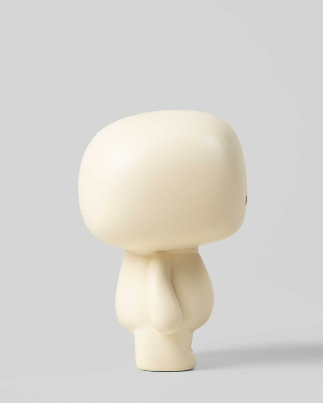 Blumo art toy figure, side profile view, on a plain grey background
